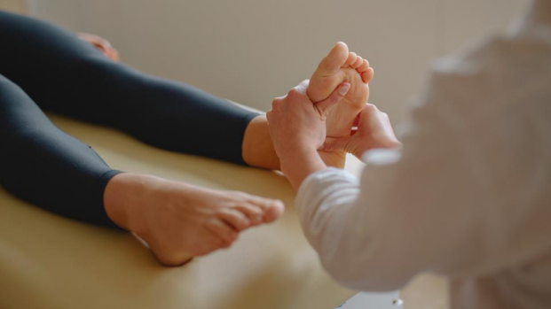 Foot specialist evaluating vibrating sensation in foot during exam
